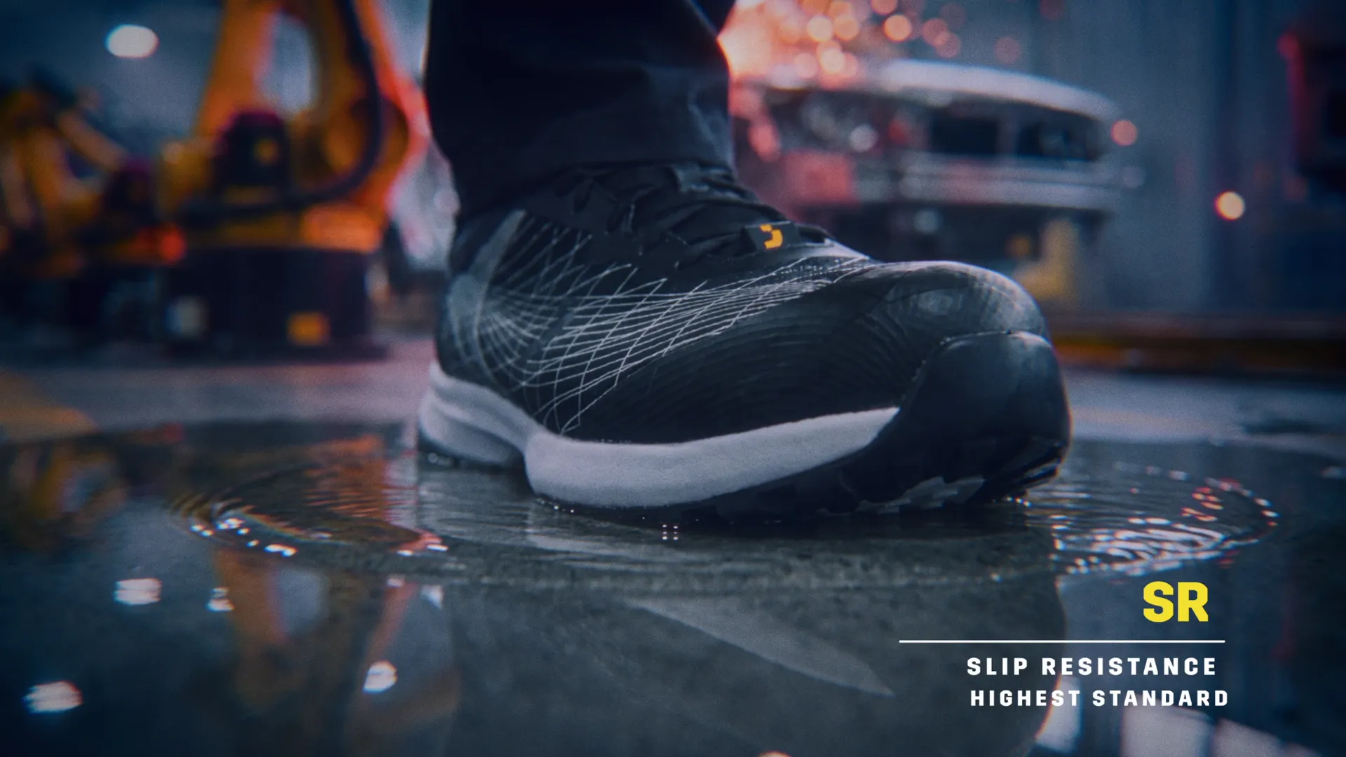 A FEATHER shoe lands on a wet car-plant floor beside robotic welding arms