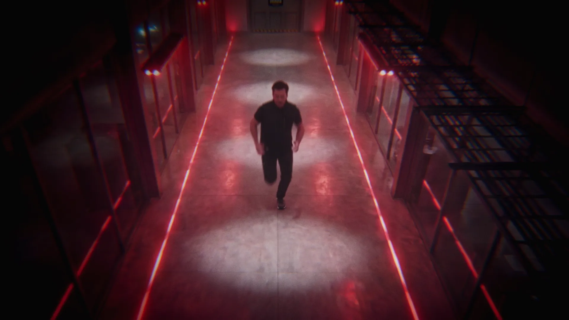 The thief runs along a red-lit corridor, viewed from above